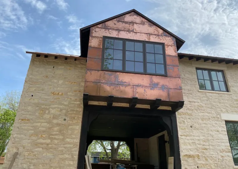Copper metal panel facade on a stone building for Roof Repair in Nibley
